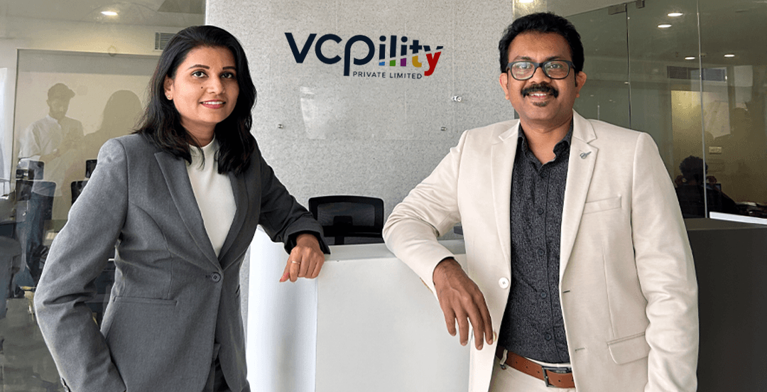 Sameer Mohan and Reshma, founders of BookMyDentist and VCPility, standing in front of VCPility office signage